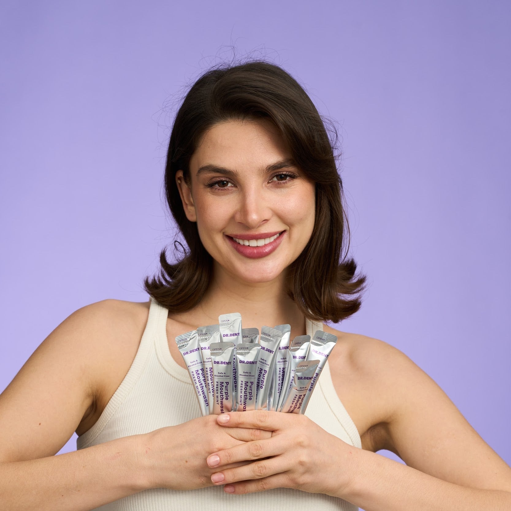 Femme tenant une dizaine de sachets de bain de bouche violet MR.SMILE Image